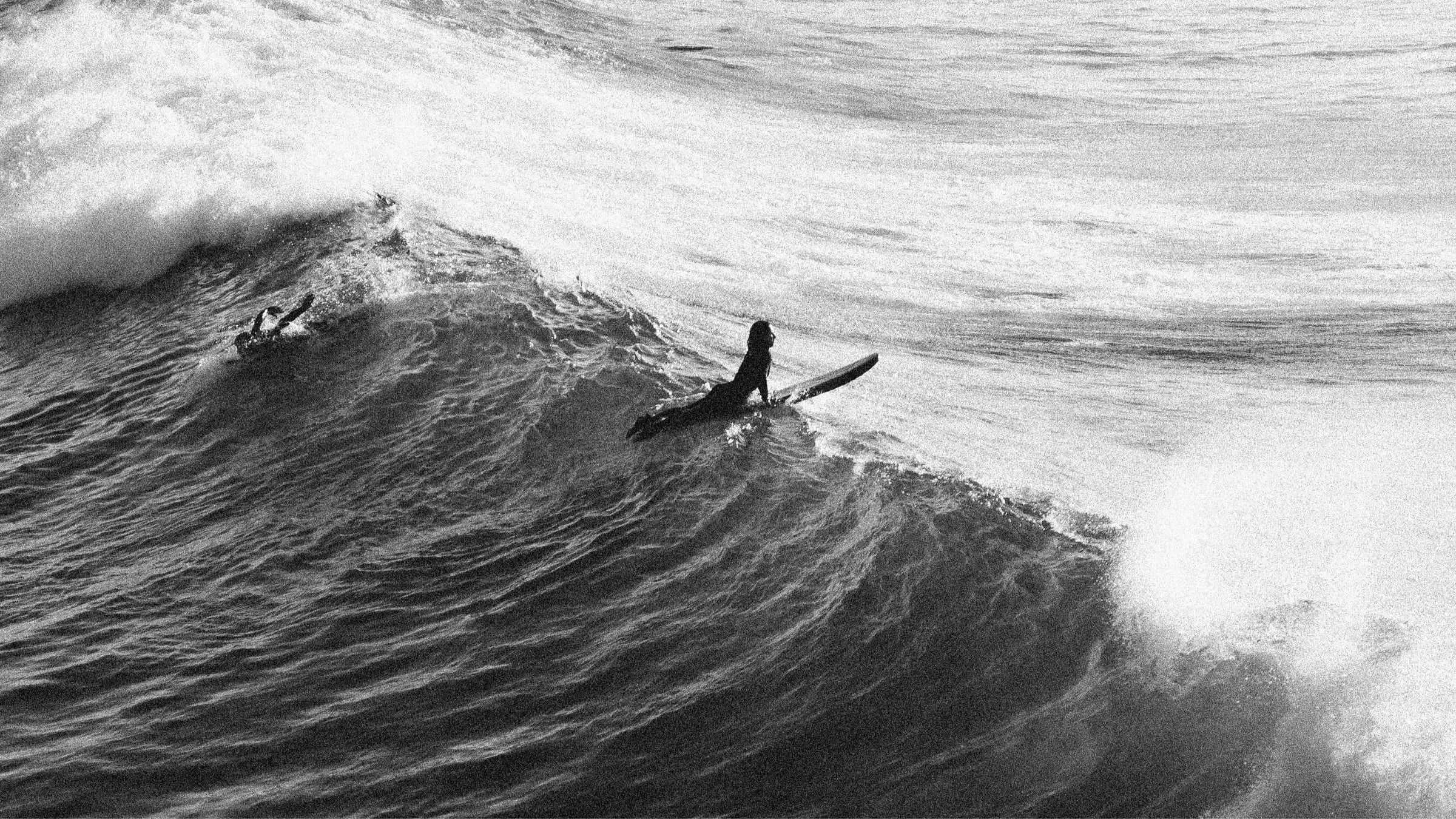 A surfer paddling over a powerful wave at the Cathedral