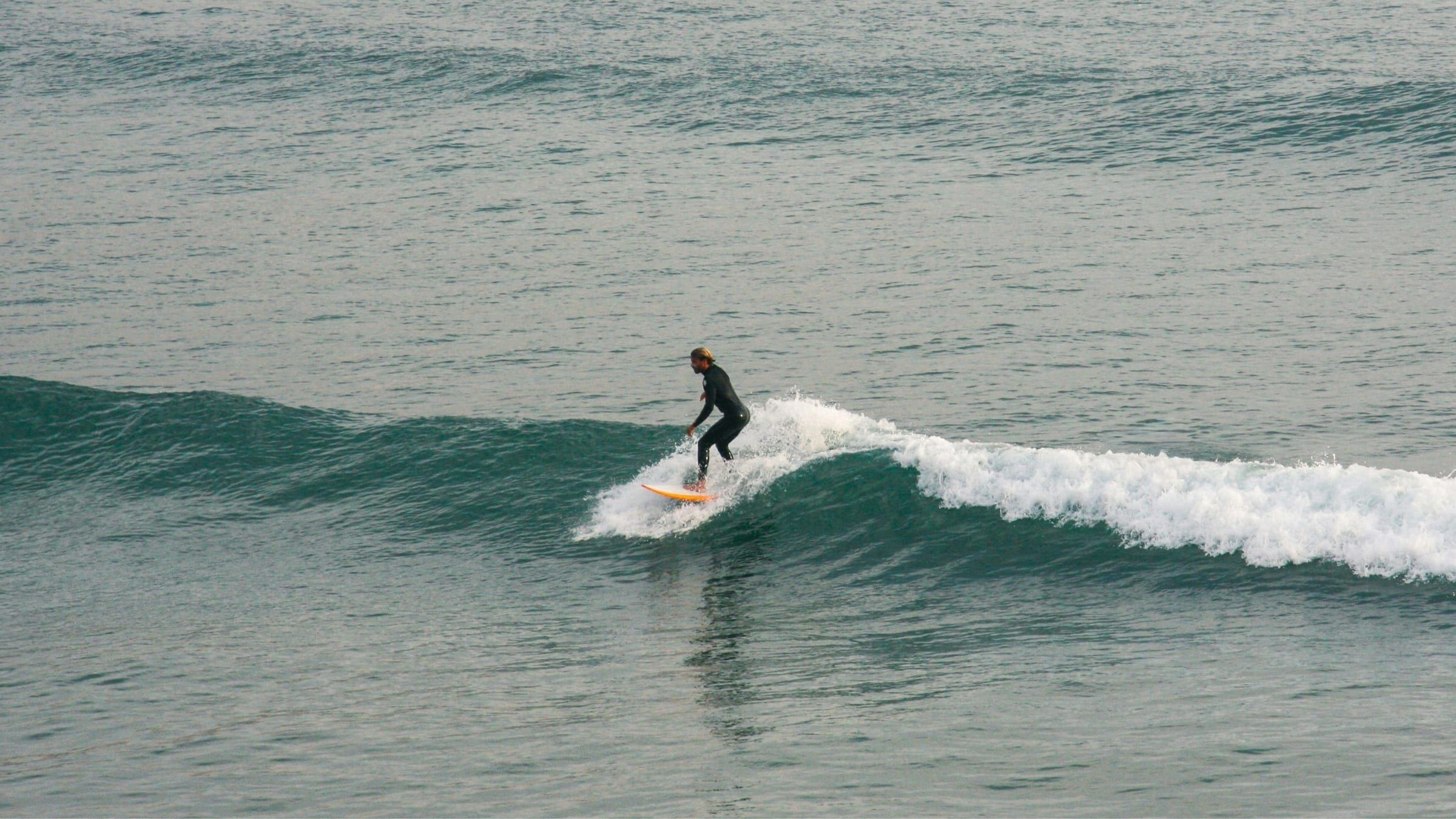 A surfer riding a wave in Imsouane, Morocco