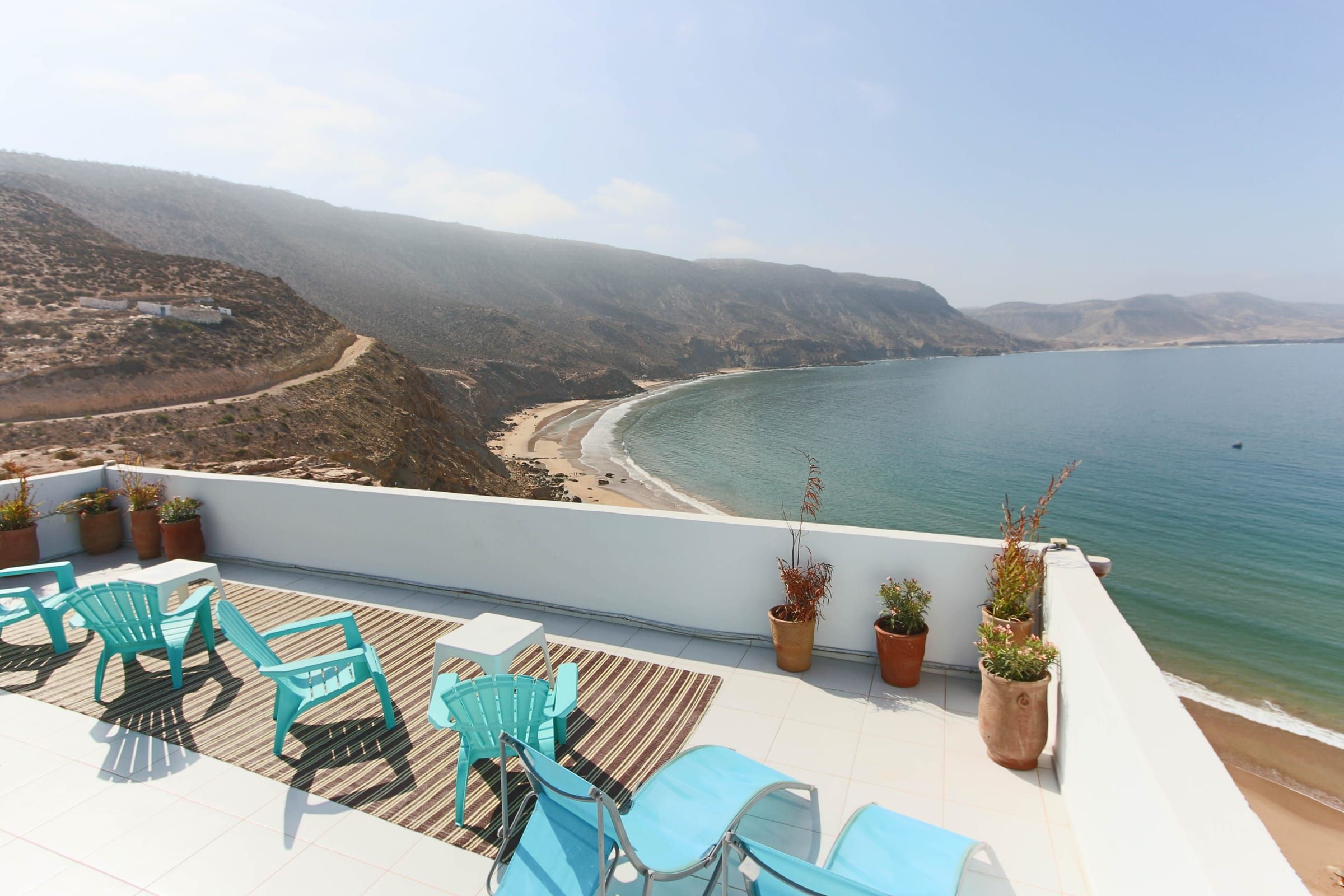 Turquoise chairs on the rooftop above the bay