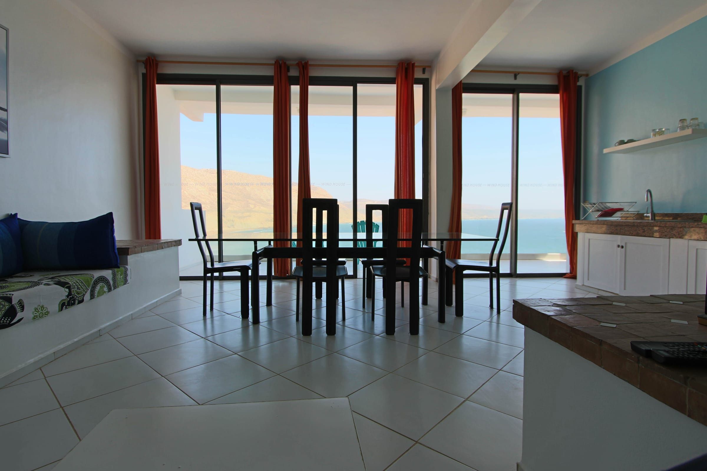 Living room with blue cushions and the bay through the windows