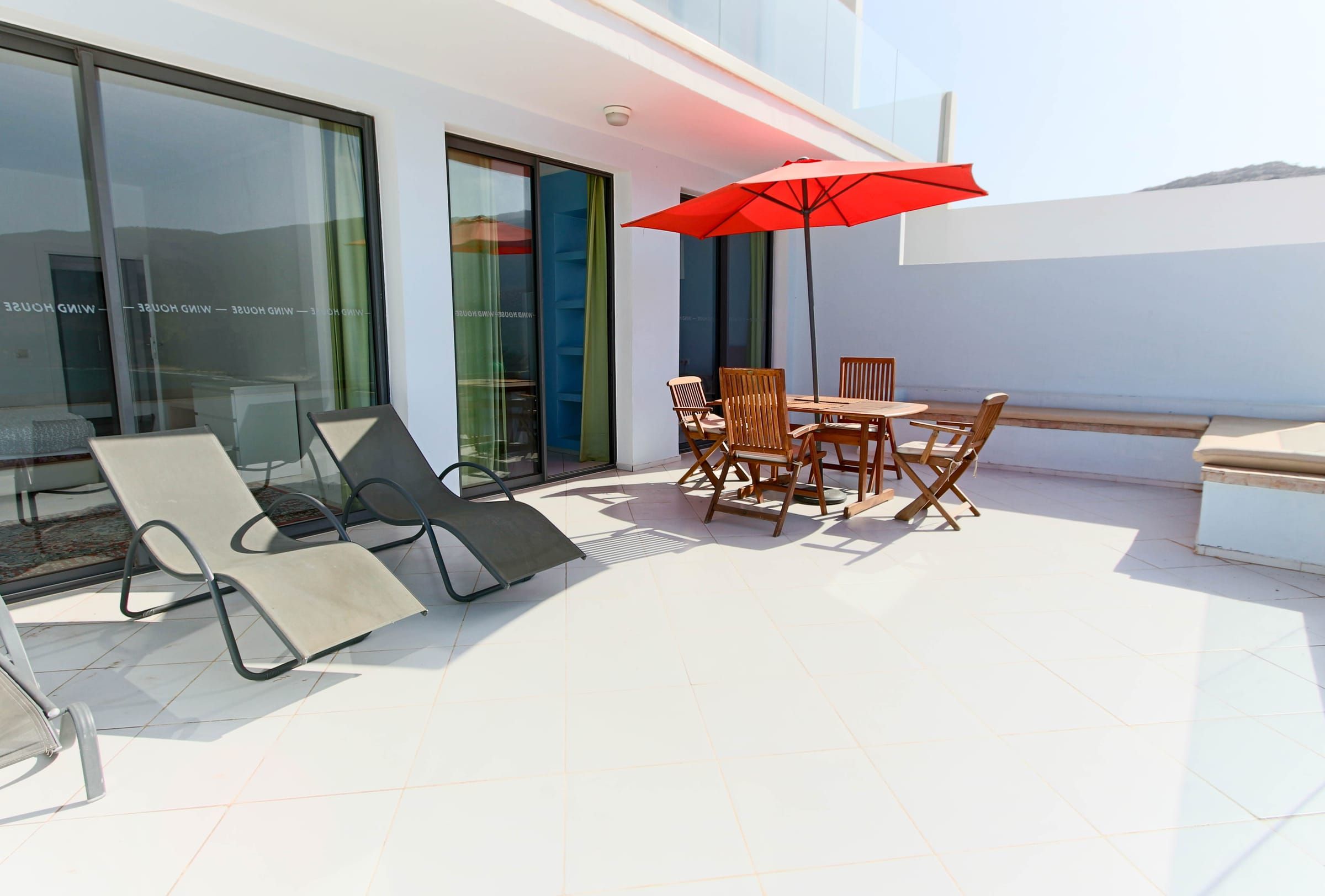 The larger terrace of the ground-floor apartment, with sun loungers