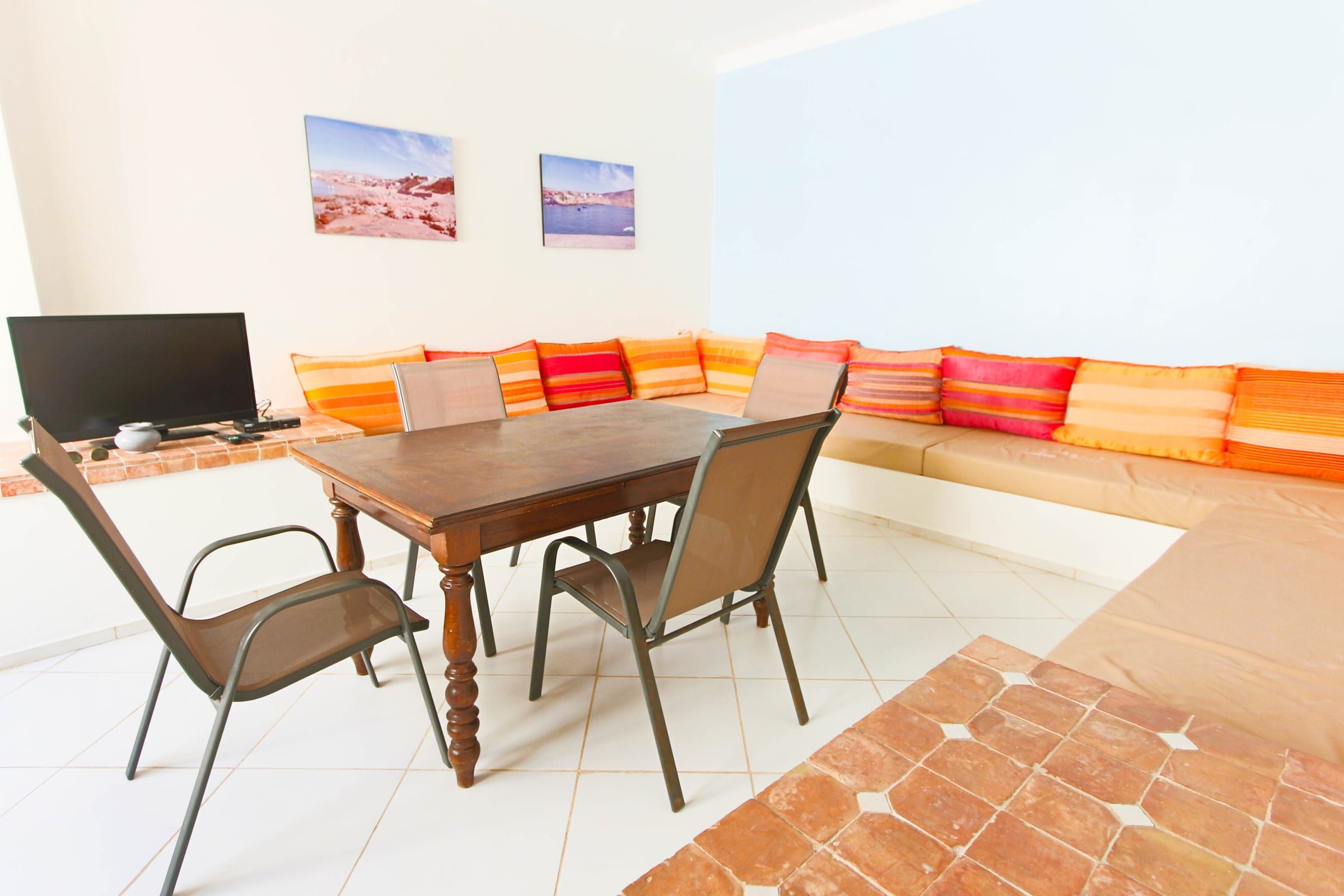 Living room with a long bench seat and orange cushions